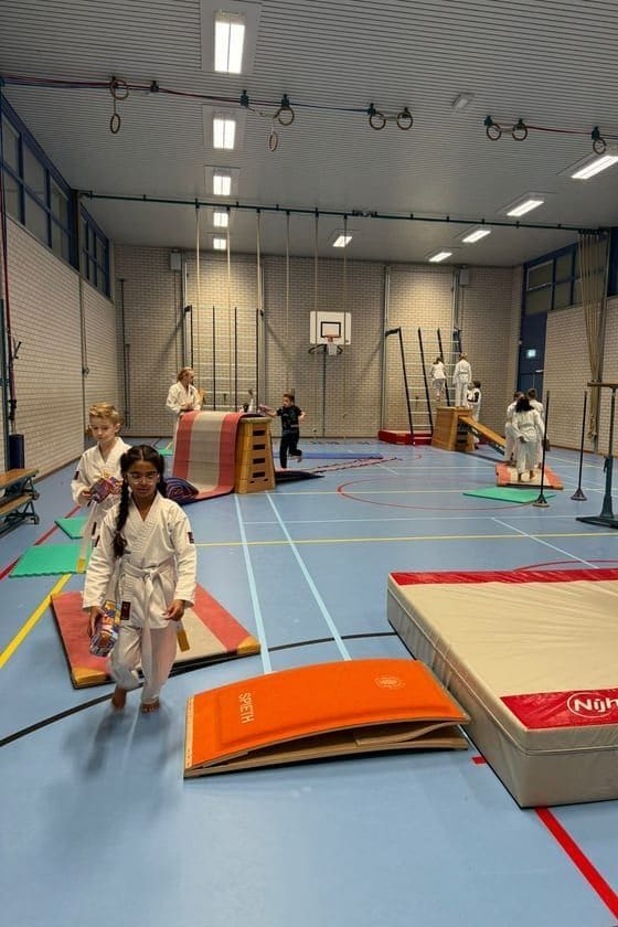 De jeugd op het hindernisparcours in de dojo
