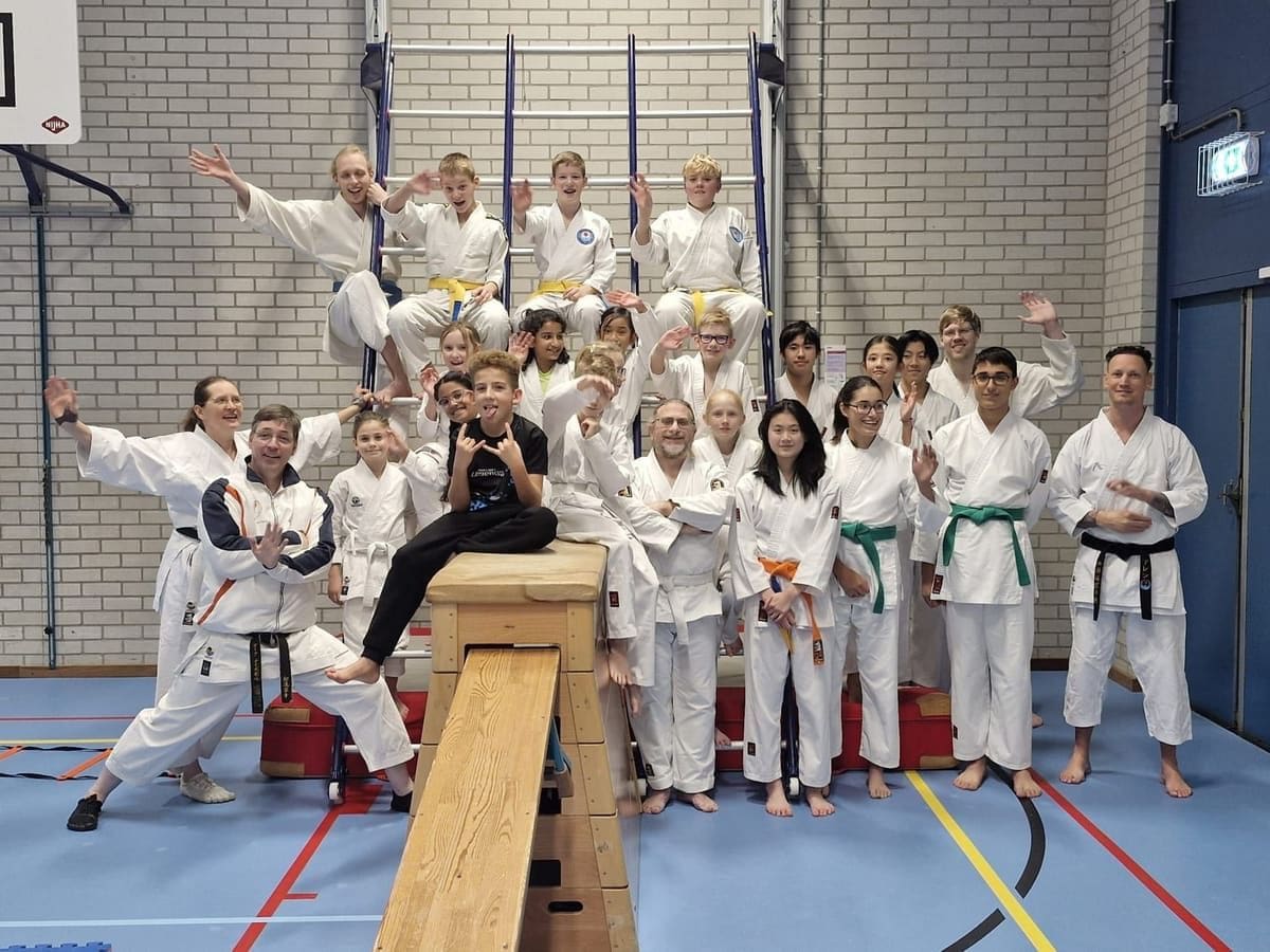 De jeugd en trainers van Tomo no Kai juichen samen in de dojo