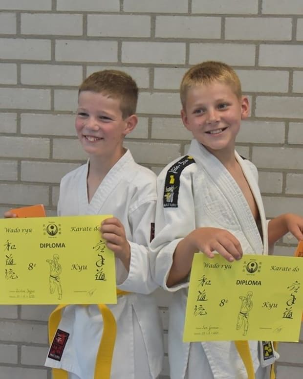 Twee jeugdleden tonen trots hun Wado-Ryu kyu-diploma