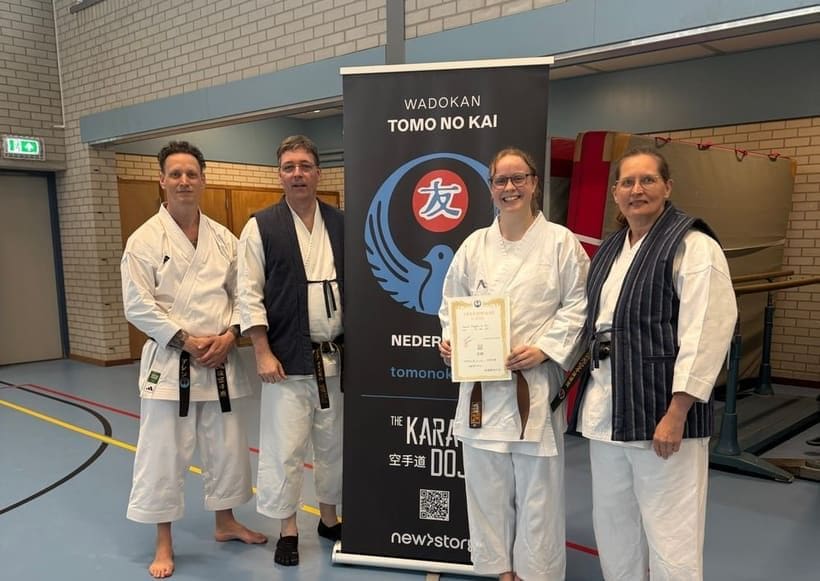 Sensei Mark en Rita met leden rond de Tomo no Kai banner na een geslaagd examen